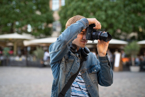 Man taking photographs with camera in town