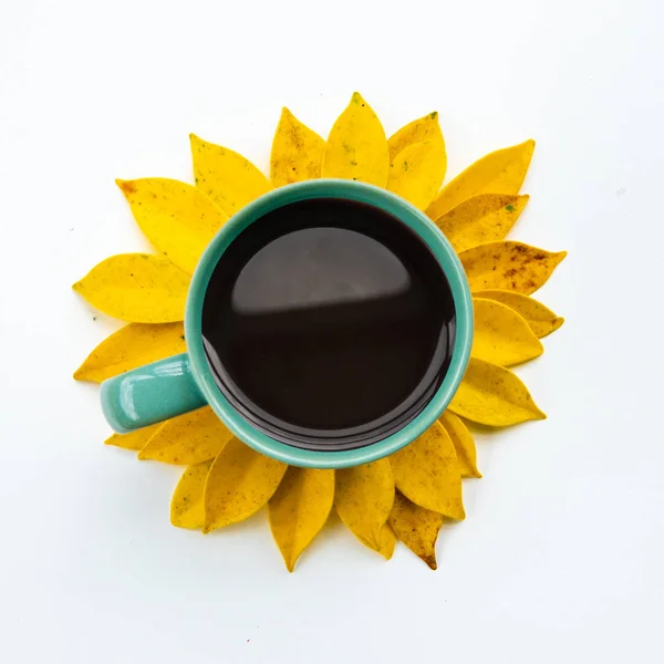 热咖啡杯与创意安排黄叶 由黄叶和咖啡杯制成的向日葵 — 图库照片