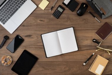 ticari aksesuarlar nesne listesi telif alanı dairesi bilgisayar dizüstü bilgisayarı, cep telefonu, tablet pasaport hesap makinesi, kalem ve gözlük listesi ile ahşap masanın üzerinde yatıyordu..