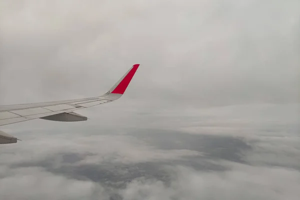 Avión ala a través de la ventana con fondo nublado . —  Fotos de Stock