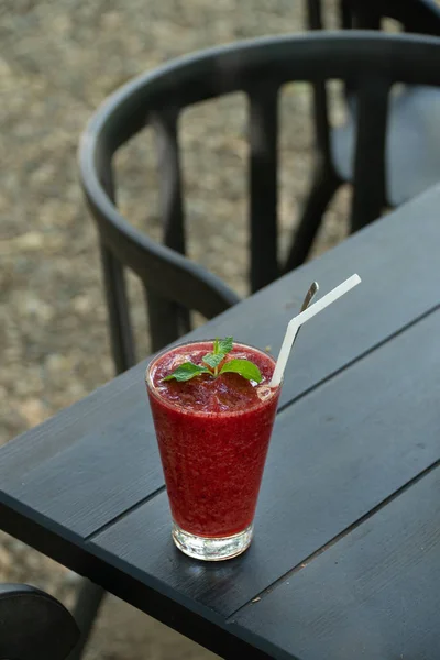 strawberry smoothie frappe on black wood table.