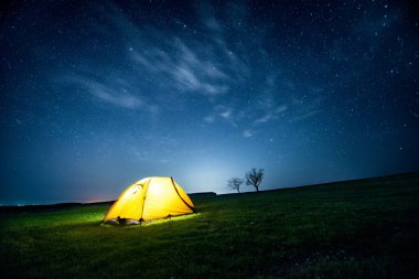 Yıldızlı gökyüzü altında gece dağda kamp çadır parlayan