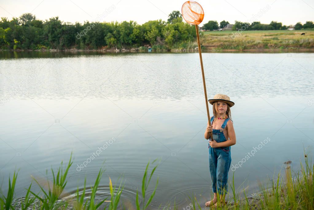 Child with a butterfly net near the river