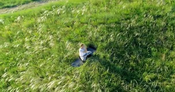 Fille Médite Assis Sur Une Belle Prairie Verte — Video