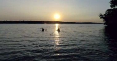 Nehrin doğal günbatımı üzerinde üzerinde kişi ile iki kayaklar