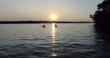 Nehrin doğal günbatımı üzerinde üzerinde kişi ile iki kayaklar