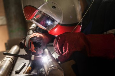 Maske bir atölyede kaynak giyen adam closeup