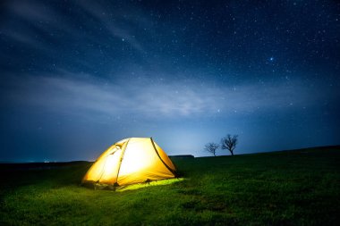 Yıldızlı gökyüzü altında gece dağda kamp çadır parlayan
