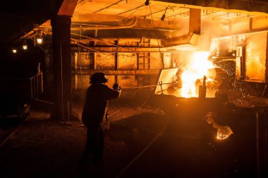 Sıvı titanyum cüruf ark ocağı üzerinden dökülen zaman işçi