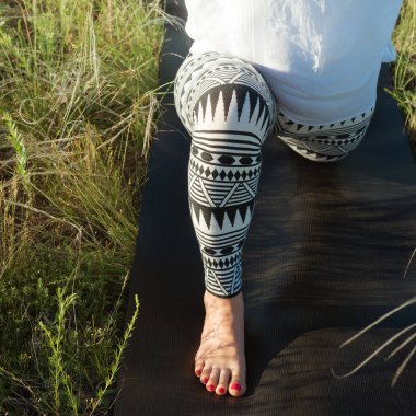 Yeşil çimenlerin üzerinde fiziksel egzersiz yaparak kız