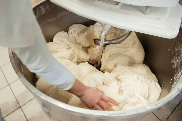Baker hamur karıştırıcısında ekmek hazırlıyor.