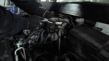 Tamircinin el bir araç ile arabanın kaputu cıvata sıkın