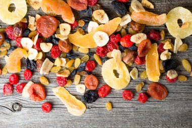 Mix of dried and candied fruit on a wooden background, top view clipart