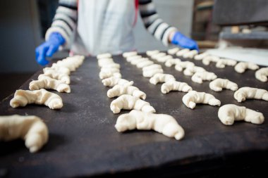 Çiğ hamur kruvasan fırın tepsisinde döşeme Baker