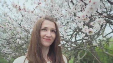 Baharda çiçek açan ağacın yanında güzel kız