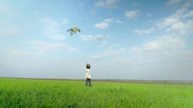 Küçük kız yeşil bir alanda bir uçurtma ile oynuyor