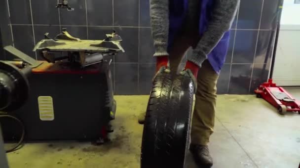 Arbeiter Rollt Ein Rad Einer Autowerkstatt — Stockvideo