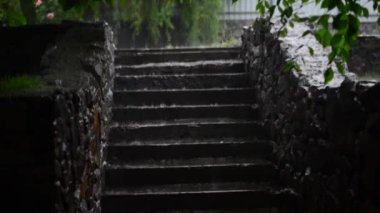 Dışarıda merdivenlerin beton basamaklarında sağanak yağmur var.