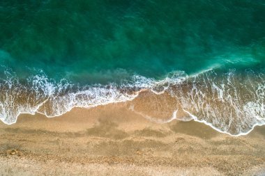 Dalgalı ve kumlu sahilli turkuaz renkli deniz manzarası. Hava görünümü.