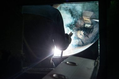 Endüstriyel kaynak yaparken iki işçi