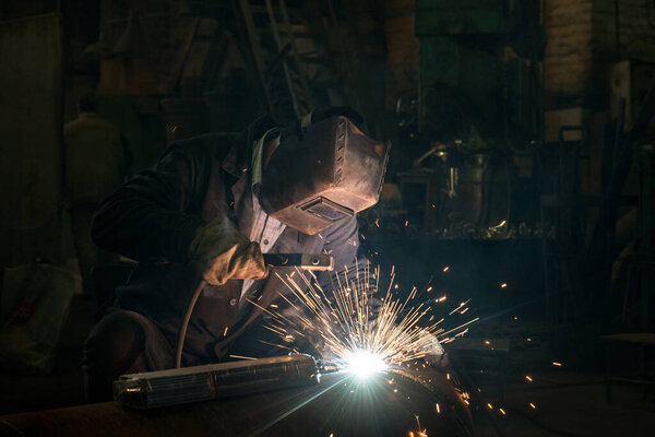 Closeup worker in a mask doing the welding in a workshop