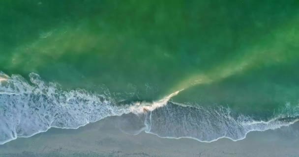 La mer pittoresque de couleur verte avec des vagues et le rivage sablonneux. Vue aérienne. Mouvement lent.
