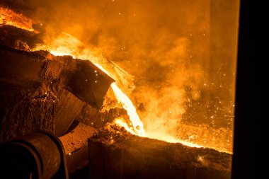Tank çelik fabrikasındaki kalıplara sıvı metal döküyor.