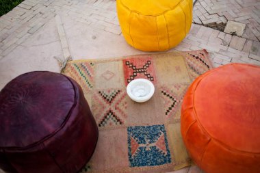 Moroccan traditional multicolored leather poufs on the carpet, Moroccan decor clipart