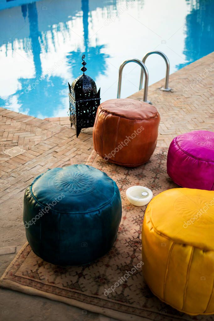 Moroccan traditional multicolored leather poufs on the carpet, Moroccan decor