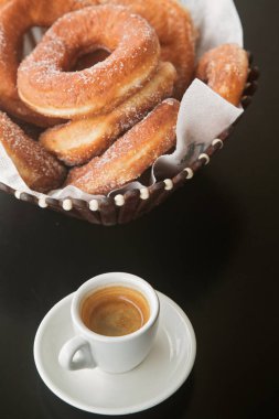 Bir tabak şekerli çörek ve bir fincan espresso kahvesi, yakın plan.