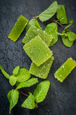 Koyu arkaplanda bir nane filizi olan yeşil marmelat.