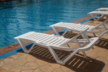 Havuzun yanındaki boş plaj sandalyeleri.