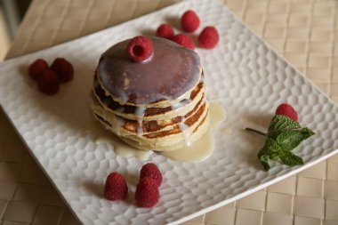 Yoğunlaştırılmış tatlı sütle kaplanmış beyaz bir tabakta vanilyalı krep.