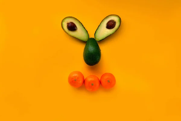 概念設計のための黄色の背景にオレンジ色のカラフルな顔アボカド果実の美しいクローズ アップ 健康的なダイエット食品です 健康的な自然食品 食品のコンセプト — ストック写真