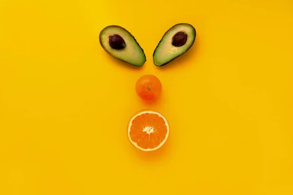 Konsept tasarımı için sarı arka plan üzerinde renkli yüzü turuncu avokado meyve güzel closeup. Sağlıklı bir diyet yemek. Sağlıklı doğal gıda. Gıda kavramı.