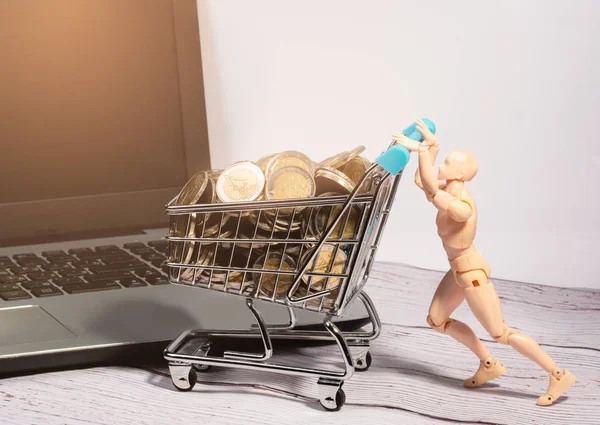 Manikin  pushes the shopping cart full of two euro coins. Concept. Free copy spece