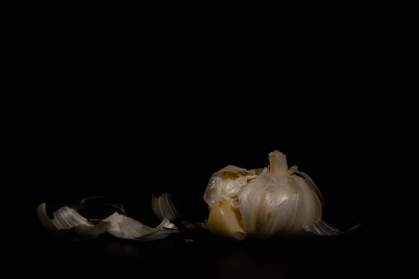 Ücretsiz bir kopyasını siyah bir zemin üzerine sarımsak closeup soyulmuş
