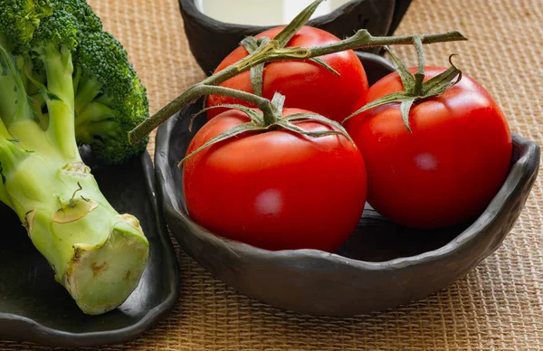 Organik sebze domates, brokoli siyah kil kase ve süt siyah kil kavanoz Jüt bez masa örtüsü, sağlıklı kavramı