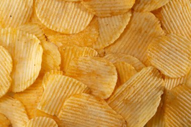 Lezzetli dalgalı sarı patates cipsi arka plan yakın çekim çok