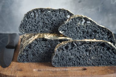 Tahtada dilimlenmiş İtalyan siyah ciabatta ekmeği  