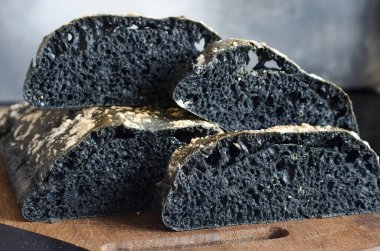 Tahtada dilimlenmiş İtalyan siyah ciabatta ekmeği  