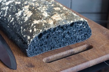 Tahtada dilimlenmiş İtalyan siyah ciabatta ekmeği  