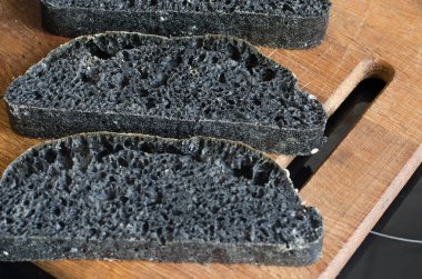 Tahtada dilimlenmiş İtalyan siyah ciabatta ekmeği  