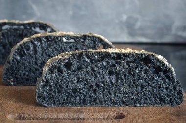 Tahtada dilimlenmiş İtalyan siyah ciabatta ekmeği  