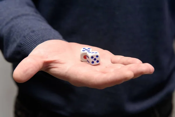 Games dice in hand. Man offers to play board games