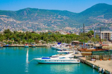 Yat limanı ve marinadaki tekneler için dağlık bir arazide rıhtım. Yat, iskele, şehir ve dağların resim yaz tatili.