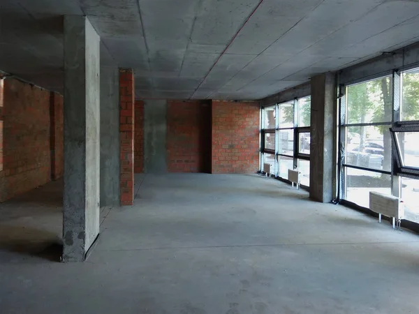 İnşaat bittikten sonra büyük boş bir oda, büyük pencerelerle tamir edilir..