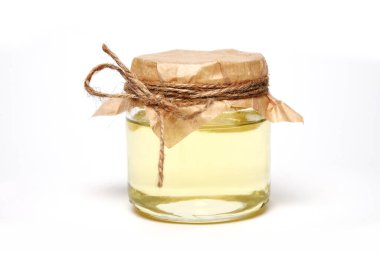 Beyaz zemin üzerinde organik ışık yağı olan kavanoz.