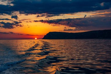Okyanusta gün batımında öfkeli deniz dalgaları. Denizde fırtına bulutları.