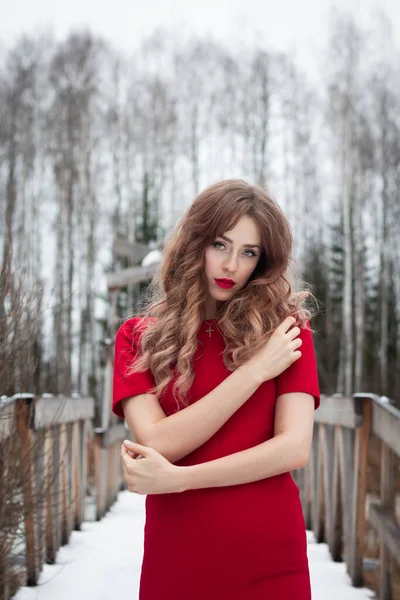 Witch girl in a red dress looks directly at the camera.